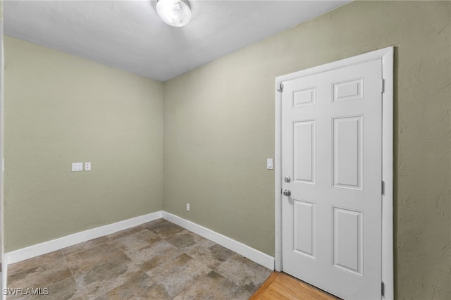 unfurnished room with baseboards