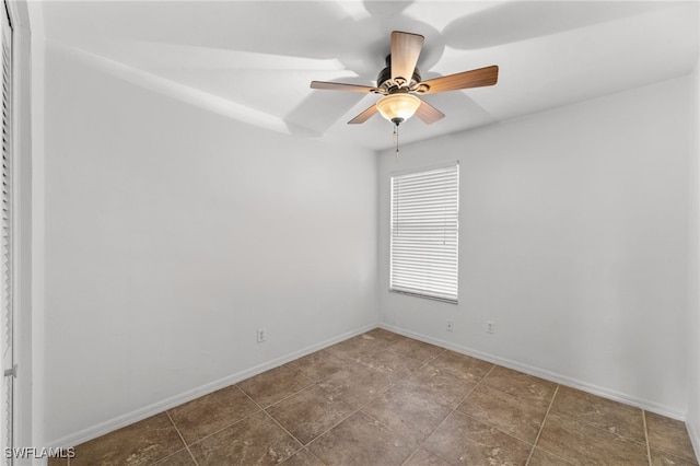 spare room with baseboards and a ceiling fan