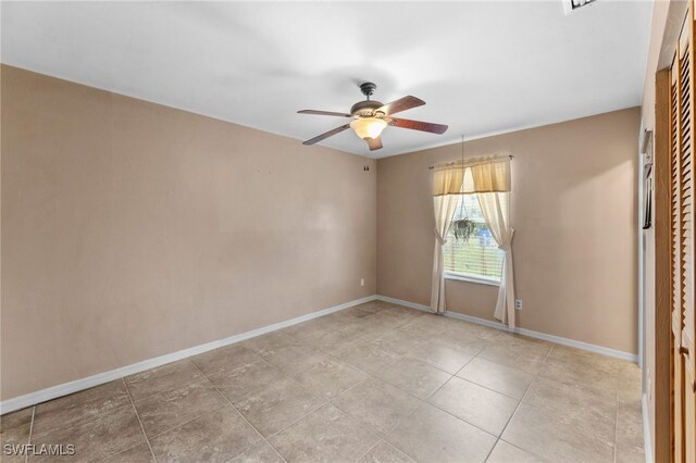 unfurnished room featuring light tile patterned floors, ceiling fan, and baseboards