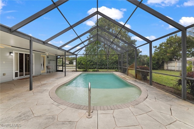 pool with a patio area, ceiling fan, fence, and glass enclosure