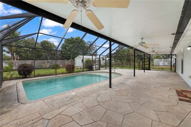 view of pool featuring a storage shed, a patio, a fenced backyard, ceiling fan, and a lanai