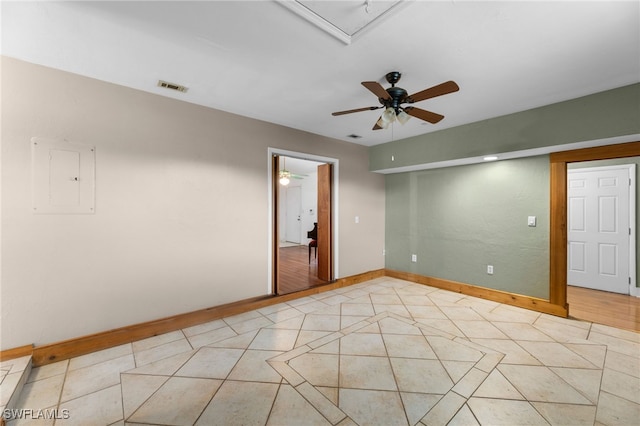 unfurnished room with light tile patterned floors, a ceiling fan, baseboards, visible vents, and electric panel