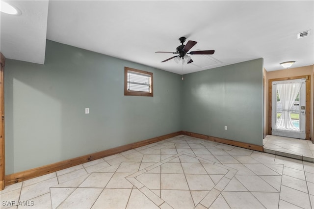 unfurnished room featuring light tile patterned floors, baseboards, visible vents, and ceiling fan