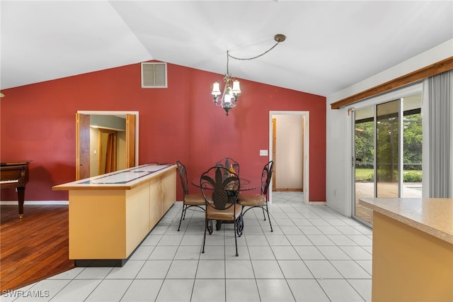 dining space with lofted ceiling, baseboards, visible vents, and a chandelier