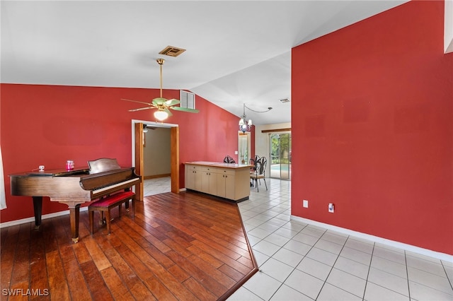 interior space with lofted ceiling, light wood-style flooring, visible vents, and baseboards