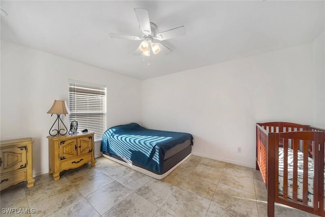 bedroom with ceiling fan and baseboards