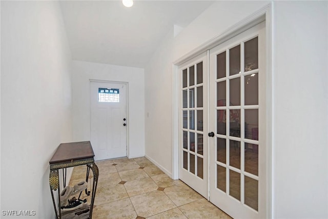 entryway featuring french doors, light tile patterned flooring, and baseboards