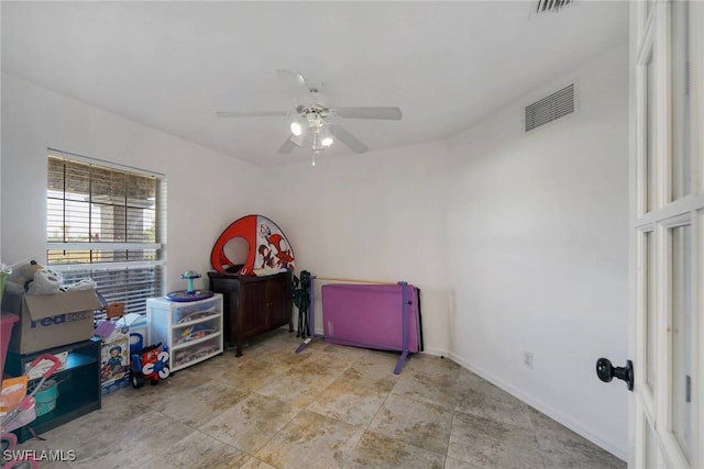 recreation room featuring a ceiling fan, visible vents, and baseboards