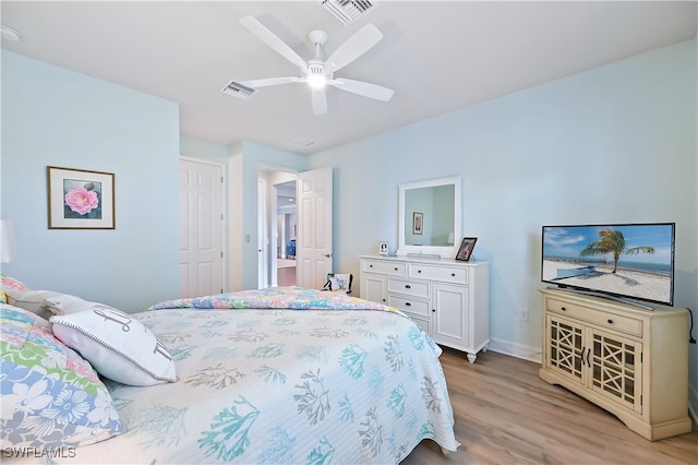 bedroom with a ceiling fan, light wood-type flooring, visible vents, and baseboards