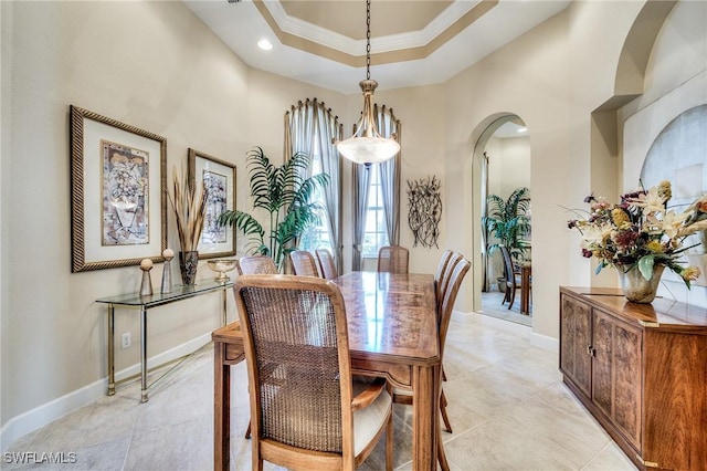 10731 Wintercress Dr, Estero, FL 34135 - dining room featuring crown molding, baseboards, a raised ceiling, light tile patterned flooring, and arched walkways