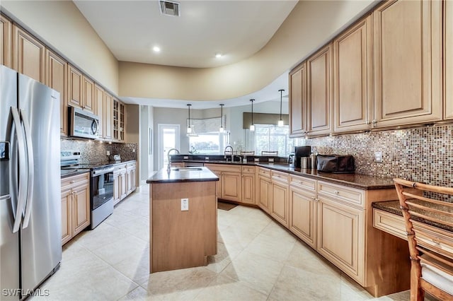 10731 Wintercress Dr, Estero, FL 34135 - kitchen with a sink, a peninsula, stainless steel appliances, a kitchen island with sink, and visible vents