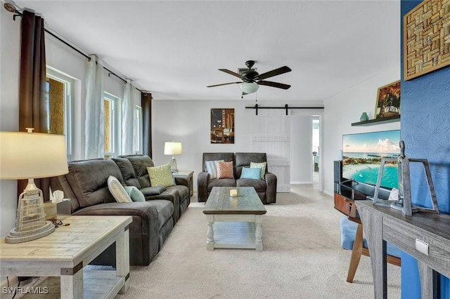 living room with carpet floors, a barn door, and a ceiling fan