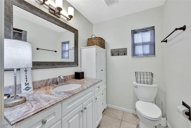 bathroom featuring visible vents, toilet, vanity, baseboards, and tile patterned floors