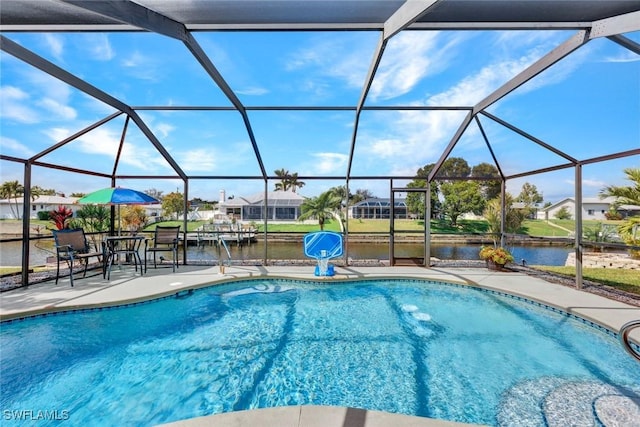 outdoor pool with a patio, a water view, and glass enclosure