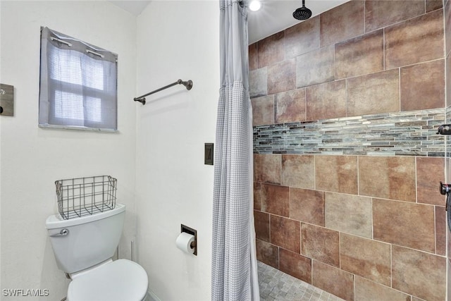 bathroom with tiled shower and toilet