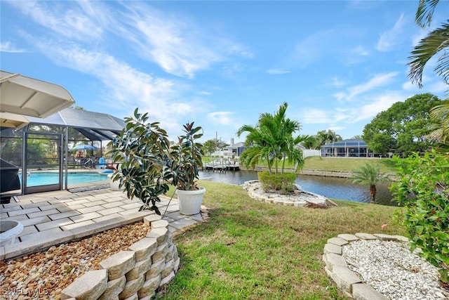 view of yard featuring a patio area, a lanai, a water view, and an outdoor pool