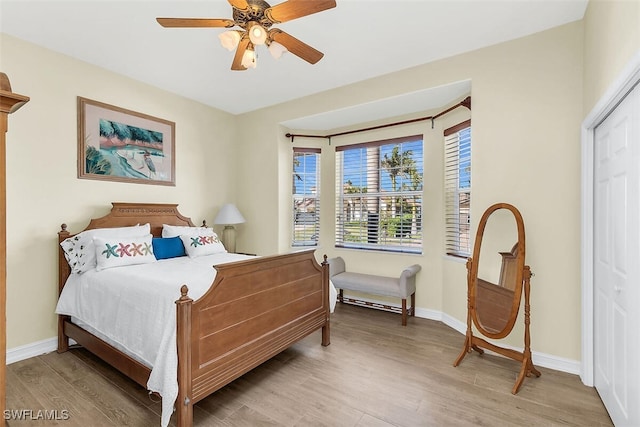 bedroom featuring ceiling fan, baseboards, and wood finished floors