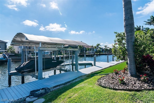 view of dock with a water view, boat lift, and a yard