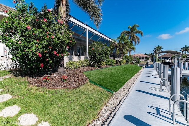 view of yard featuring a dock and glass enclosure