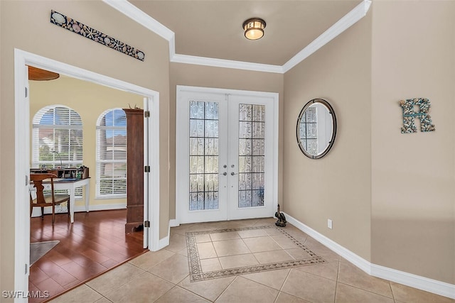 foyer entrance featuring french doors, a healthy amount of sunlight, crown molding, and light tile patterned floors