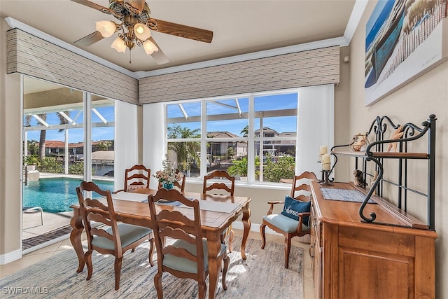 dining room with a sunroom, ceiling fan, light tile patterned floors, and baseboards