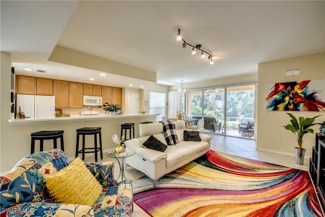 living area featuring light tile patterned floors, recessed lighting, visible vents, baseboards, and track lighting