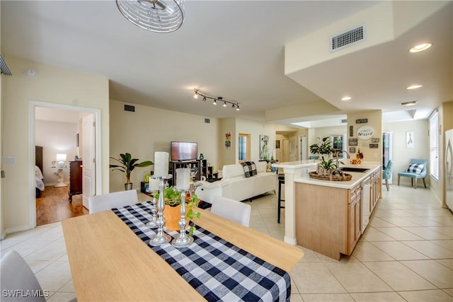 kitchen featuring light tile patterned floors, visible vents, open floor plan, and a sink