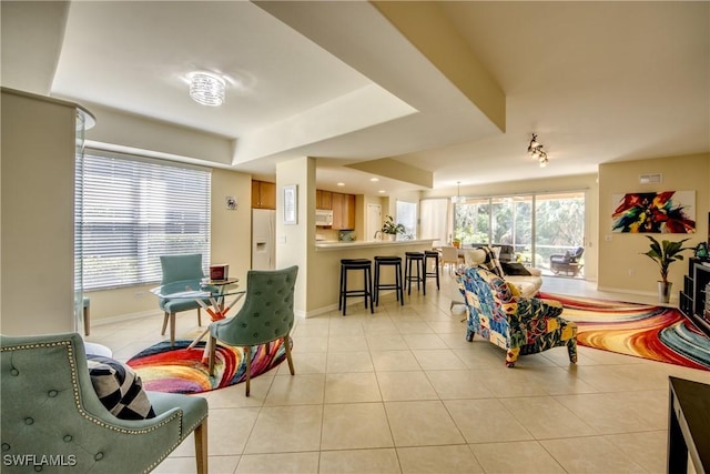 living room featuring light tile patterned flooring, visible vents, and baseboards