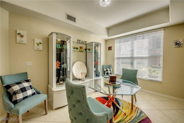 living area with baseboards, visible vents, and tile patterned floors