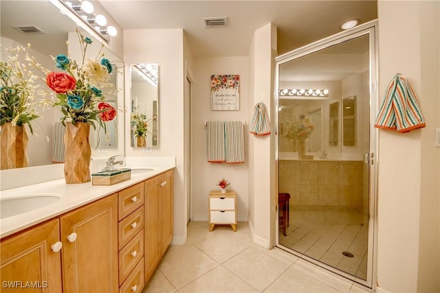 full bath featuring tile patterned flooring, visible vents, a sink, and tiled shower