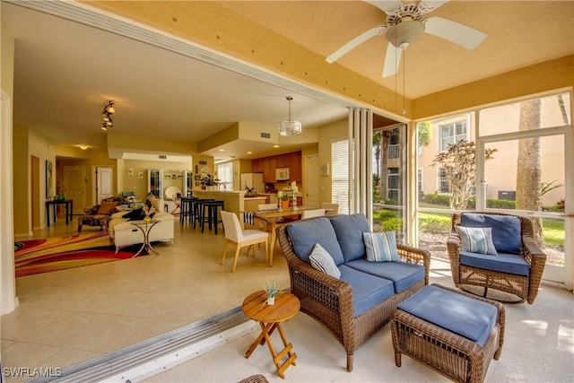 sunroom featuring visible vents and a ceiling fan