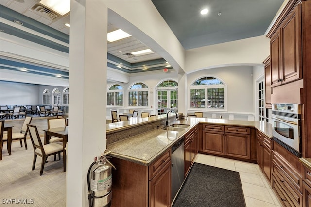 kitchen with light tile patterned floors, visible vents, appliances with stainless steel finishes, stone countertops, and a sink