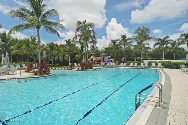 community pool featuring playground community and a patio