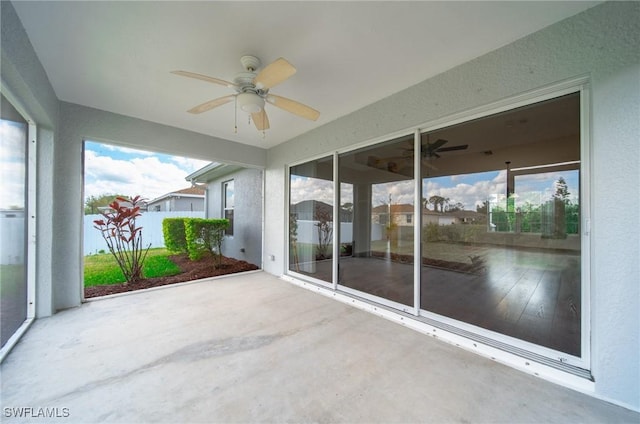 unfurnished sunroom featuring a ceiling fan