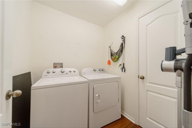 clothes washing area with laundry area, dark wood finished floors, baseboards, and separate washer and dryer