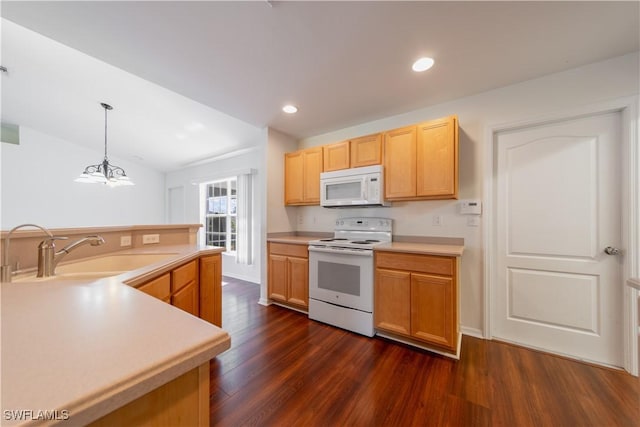 kitchen with white appliances, dark wood-style flooring, light countertops, a sink, and recessed lighting