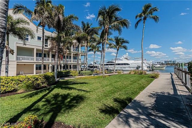 surrounding community with a water view and a yard