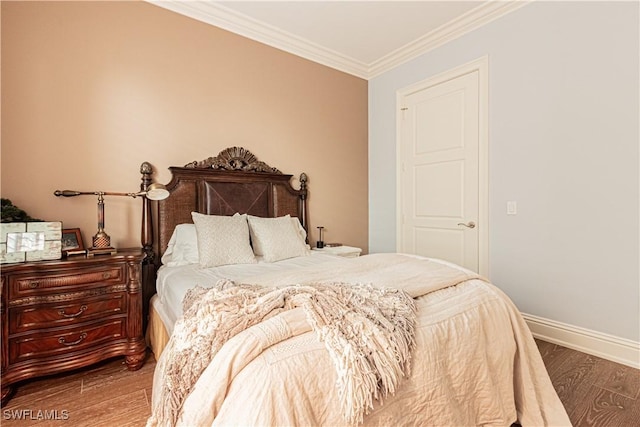 bedroom with baseboards, ornamental molding, and wood finished floors