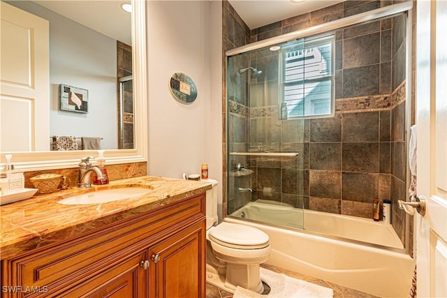 full bathroom featuring toilet, enclosed tub / shower combo, and vanity