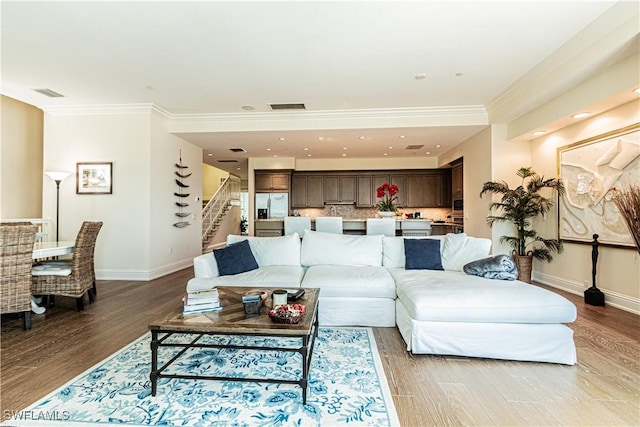 living room featuring stairs, wood finished floors, visible vents, and baseboards