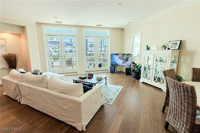 living area featuring ornamental molding, visible vents, and wood finished floors