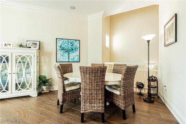 dining space with ornamental molding, baseboards, and wood finished floors