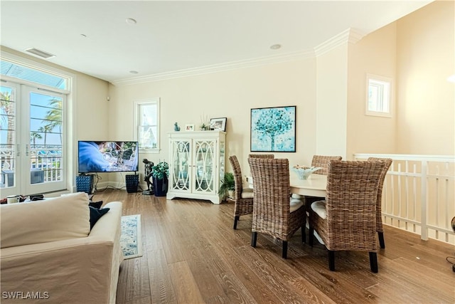 dining room with crown molding, visible vents, wood finished floors, and french doors