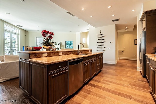 kitchen with visible vents, light wood-style flooring, appliances with stainless steel finishes, open floor plan, and a sink