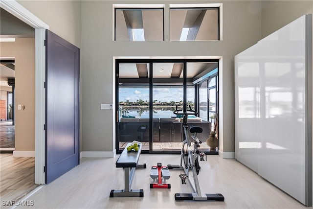 exercise area featuring light wood-style floors and baseboards