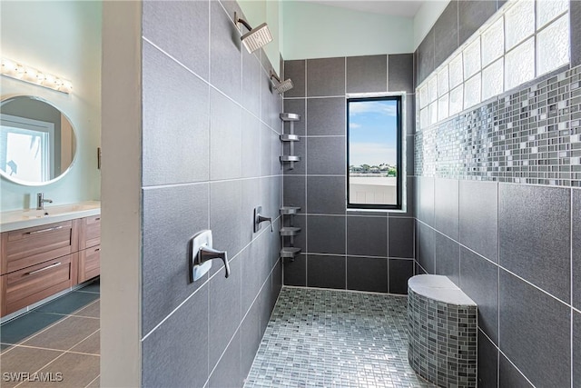 bathroom featuring a tile shower, vanity, and tile patterned floors