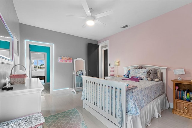 bedroom featuring ceiling fan, light wood finished floors, visible vents, and baseboards