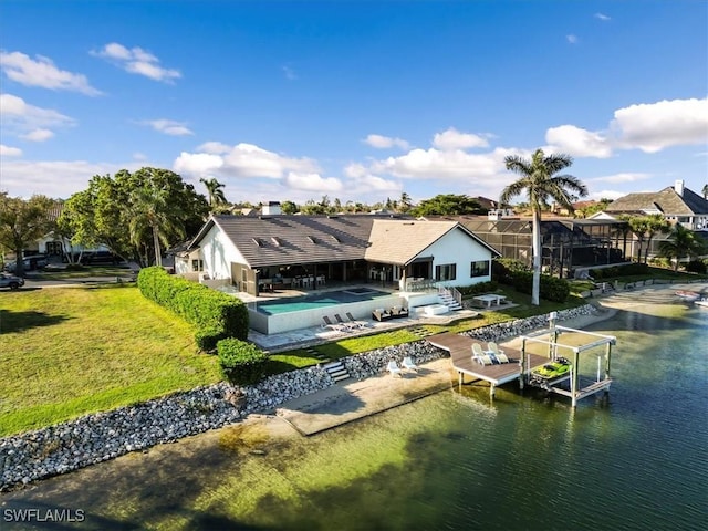 rear view of property featuring a patio, boat lift, a water view, a lawn, and an outdoor pool