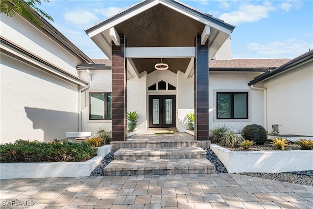 entrance to property featuring french doors and stucco siding