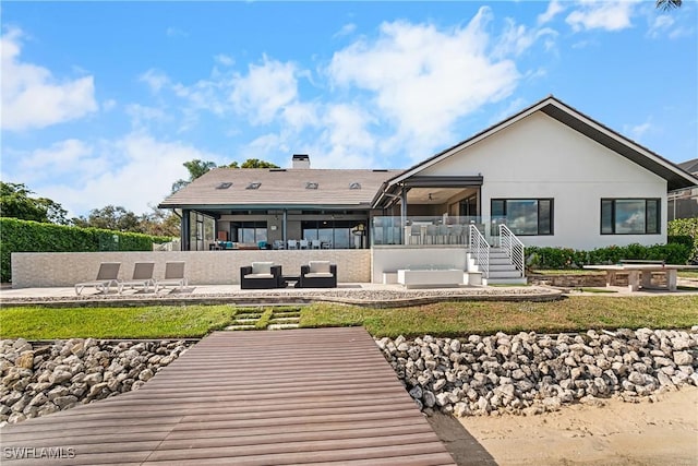 rear view of property with an outdoor hangout area, a patio area, and stucco siding